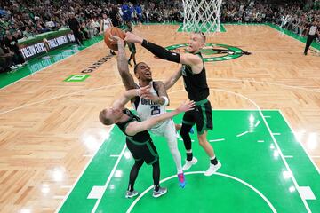 Boston Celtics forward Sam Hauser (left) and center Kristaps Porzingis (right) block P.J. Washington.